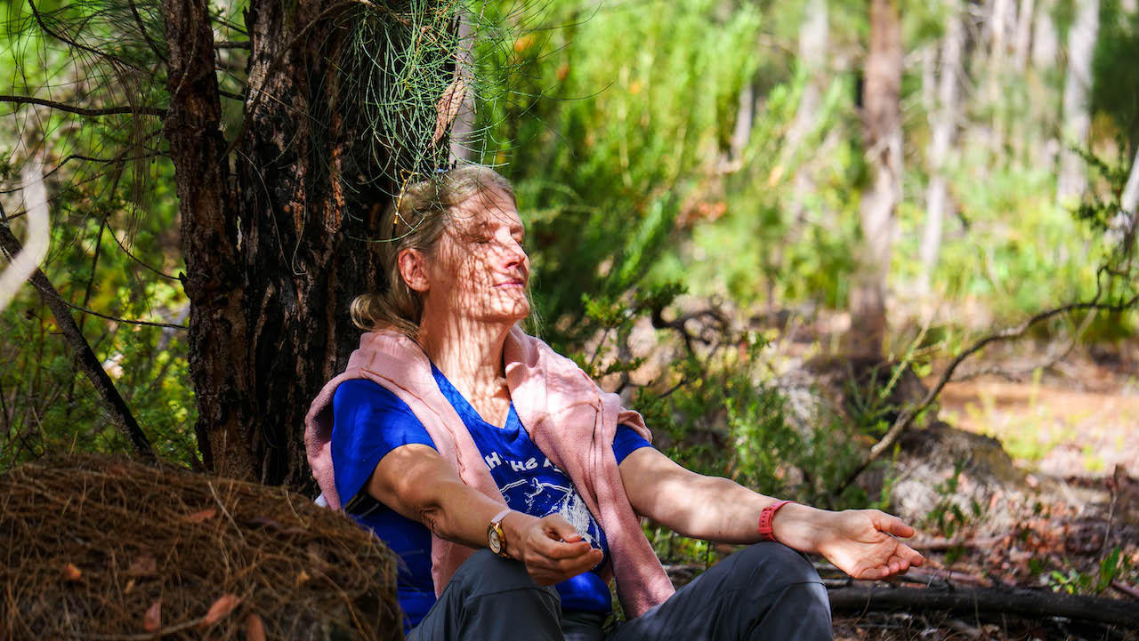 Christina Burki meditating in the forrest left